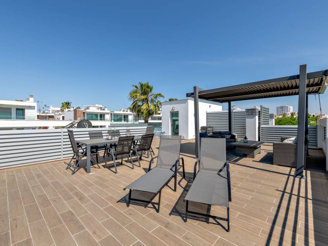 Grande terrasse sur le toit avec transats et table repas