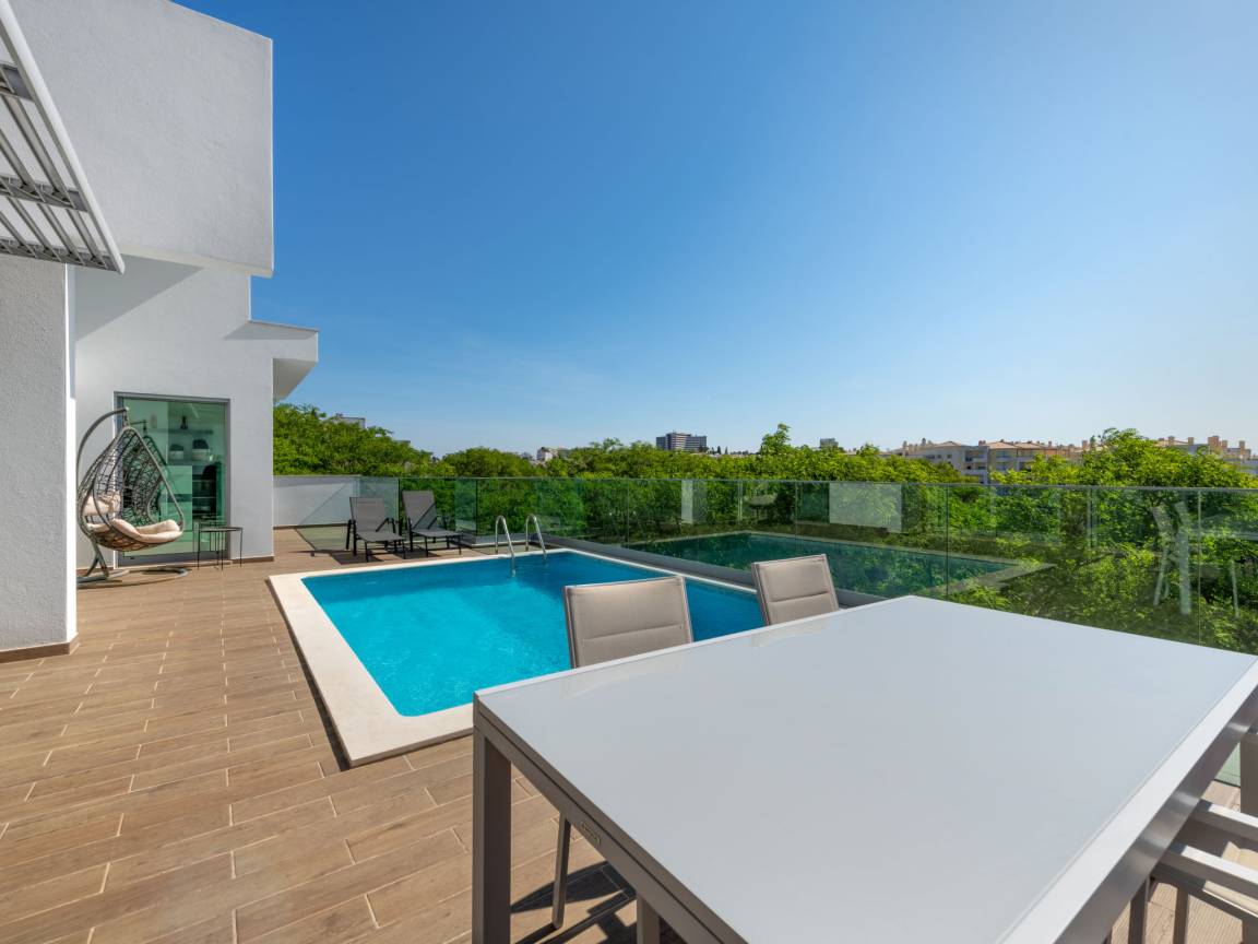 Piscine et terrasse avec fauteuil suspendu et bains de soleil